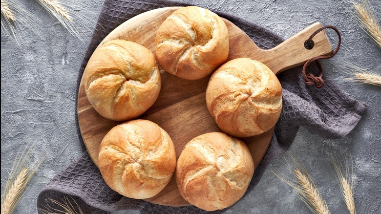 Kaiser rolls on a wooden serving board