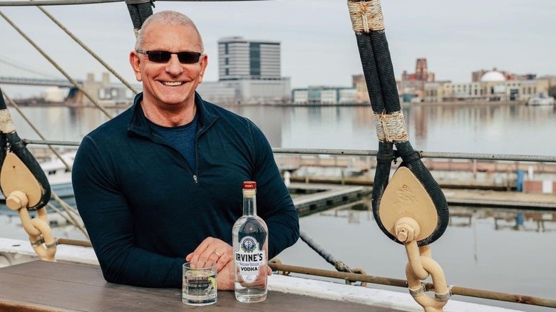 Robert Irvine smiling with vodka bottle