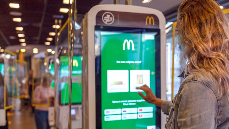 Woman using McDonald's self-serve kiosk