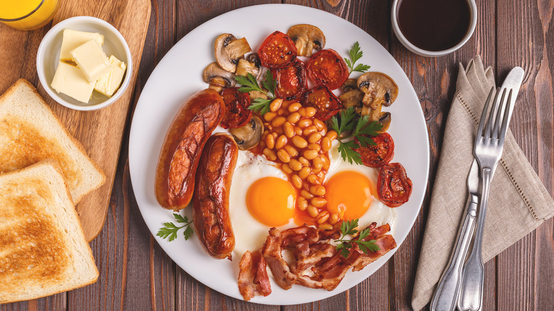 Full English breakfast platter on wood table