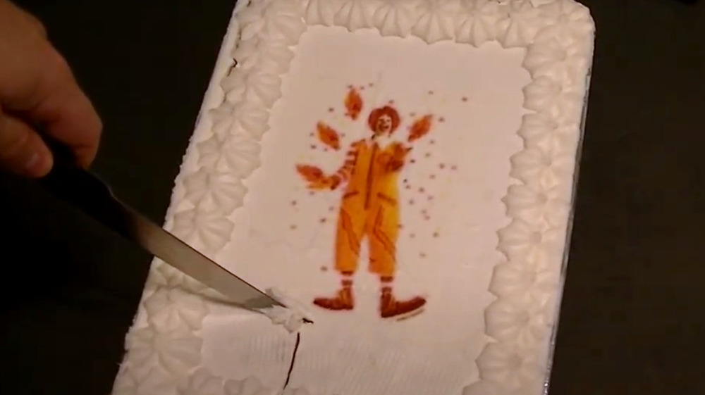 Man cutting into McDonald's sheet cake
