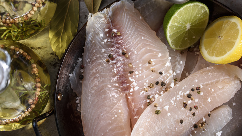Raw tilapia with leamons and seasoning