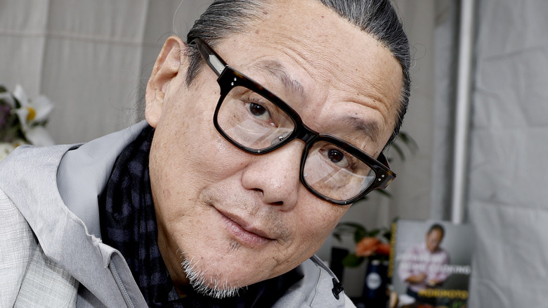 Chef Morimoto posing by book