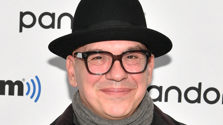 Michael Symon wearing a hat and glasses