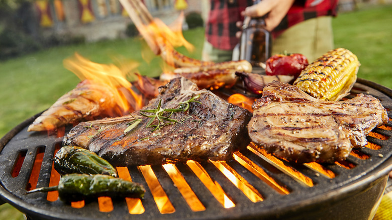 Meat and vegetables on a flaming grill