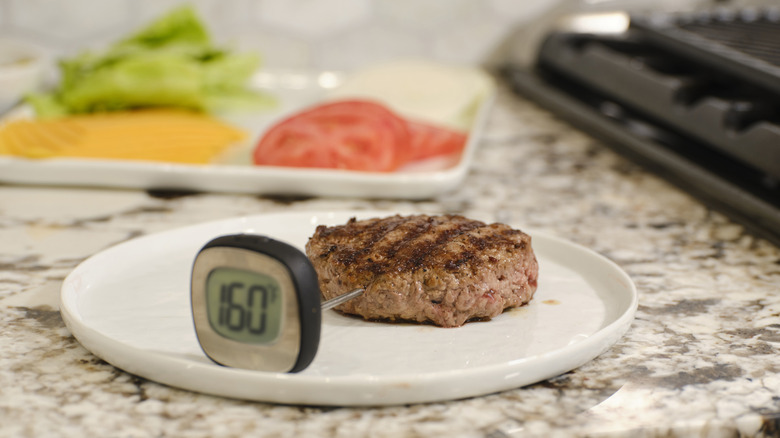 Grilled burger with a meat thermometer sticking out