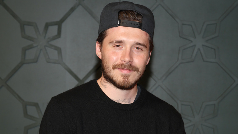 Brooklyn Beckham photographed at public event wearing a backwards hat