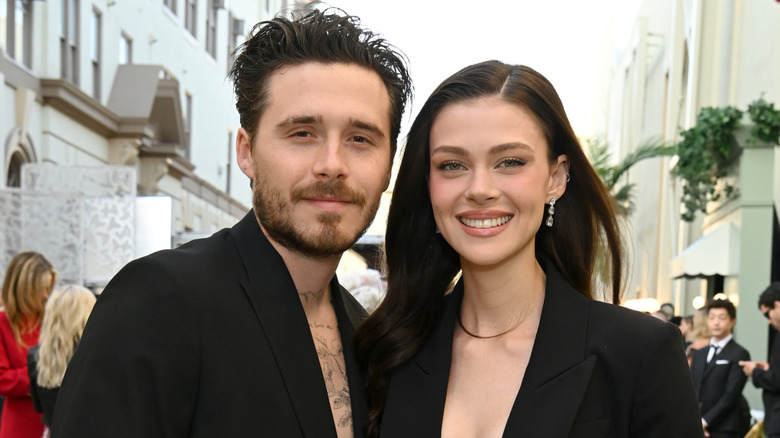 Brooklyn Beckham and wife Nicola Peltz smiling outside