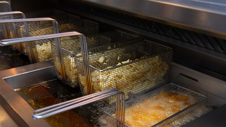 Baskets of fried foods on deep fryer