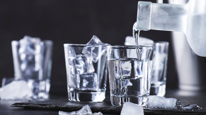 vodka pouring over ice glass