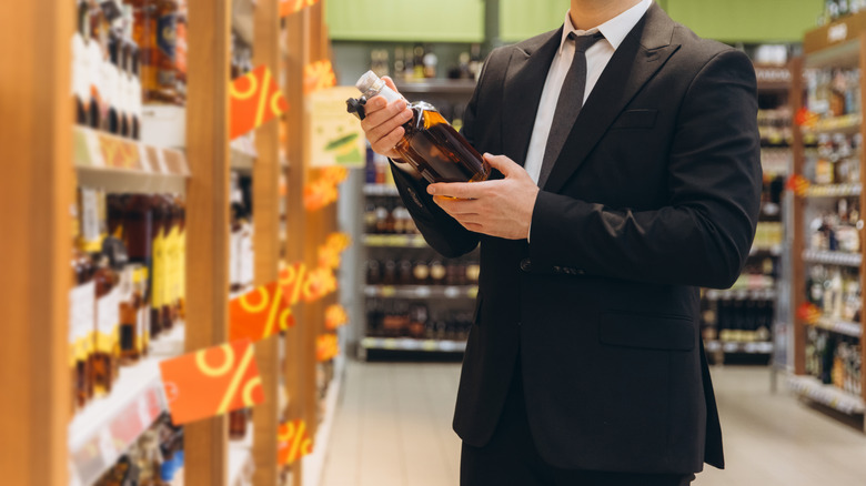 Customer looking at bottle of whiskey