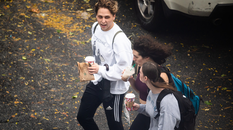 people walking with starbucks cups