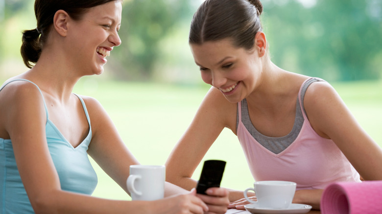 women with coffee and yoga mat