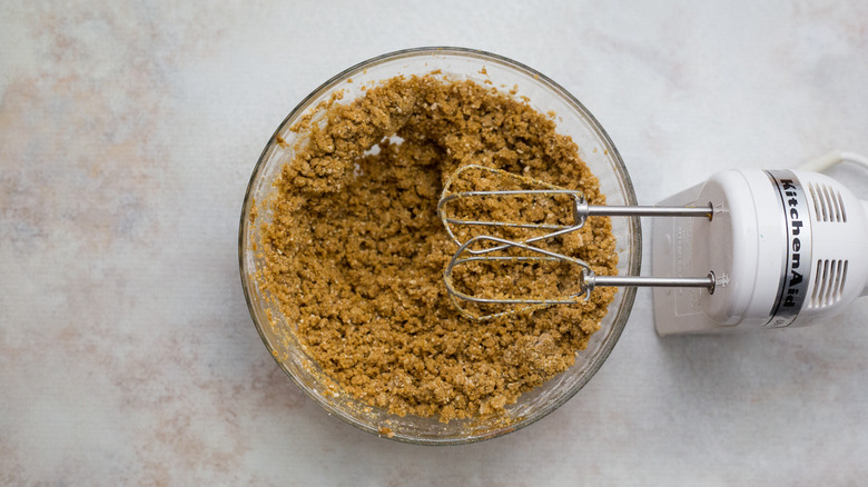 crumbly cookie dough in bowl with electric mixer