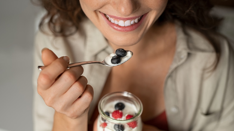 woman eating yogurt with berries