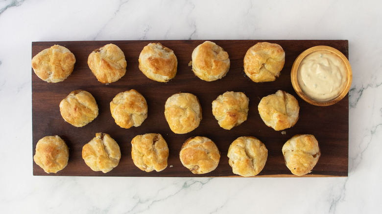 Beef Wellington bites with Dijon dip on wooden board