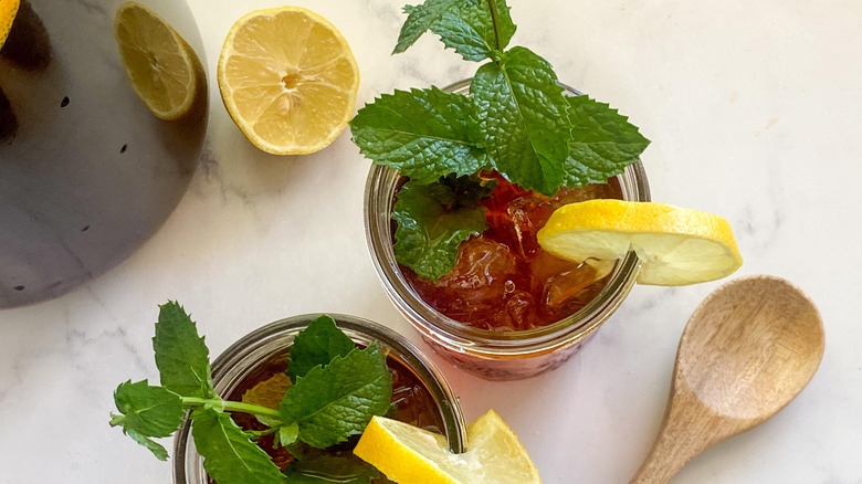 sweet southern-style tea in two glasses with mint leaves and lemon wedges