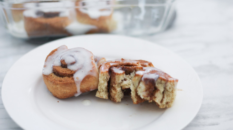 cinnamon rolls with icing on a white plate