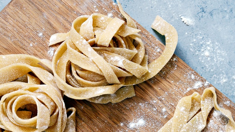 fresh homemade uncooked egg noodles dusted with flour