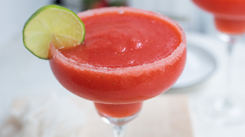 frozen strawberry margarita garnished with lime wedge