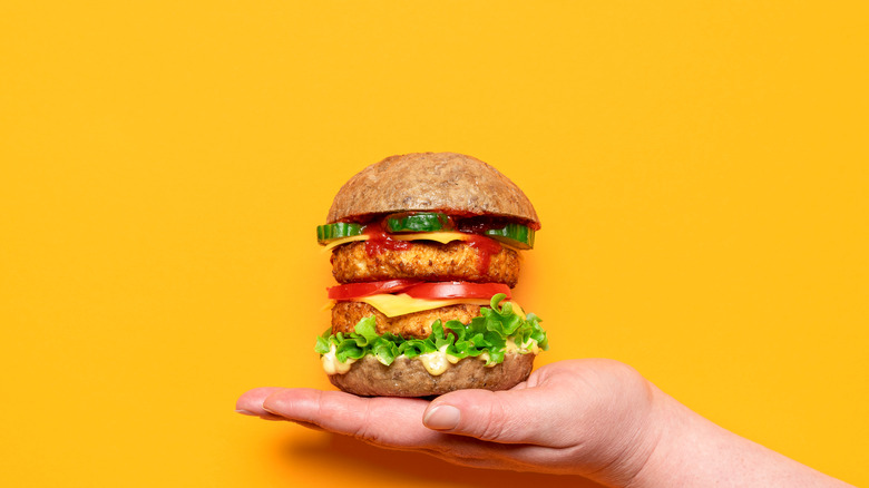 hand holding double hamburger