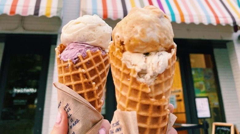 Two people holding waffle cones with Jeni's