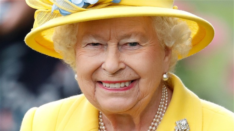 Queen Elizabeth II smiling in yellow