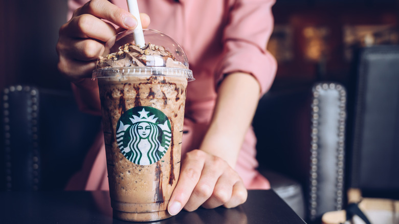 person holding Starbucks cold drink