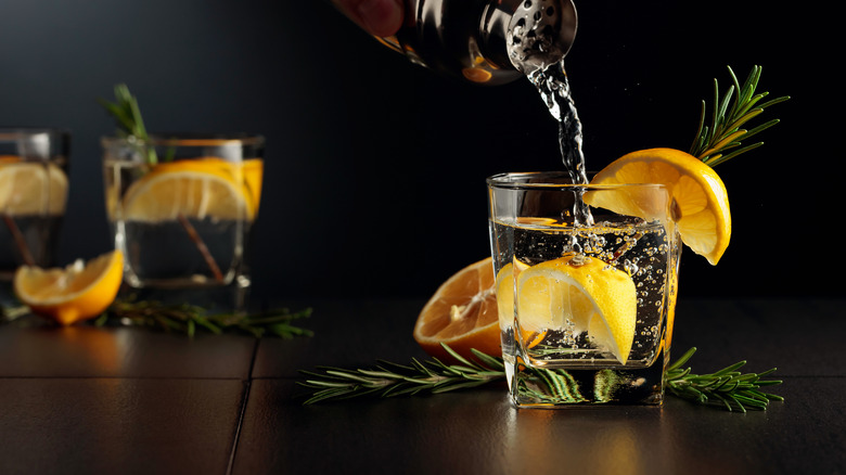 Gin and tonic being poured into glass