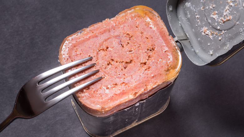 opened corned beef can with fork