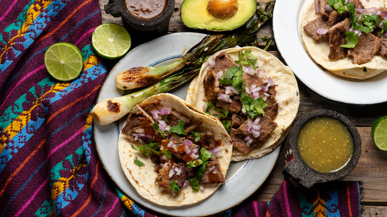 carne asada tacos with salsa on a Mexican blanket