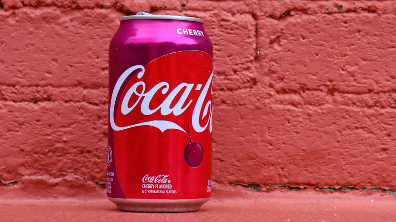Cherry coke in front of a red brick wall