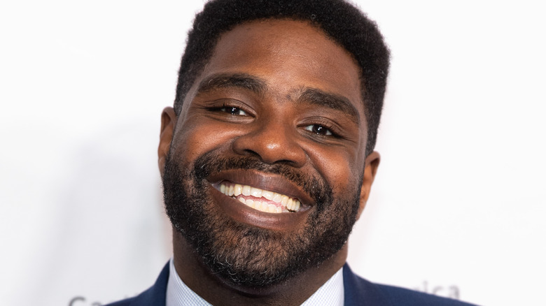 Ron Funches smiling in suit