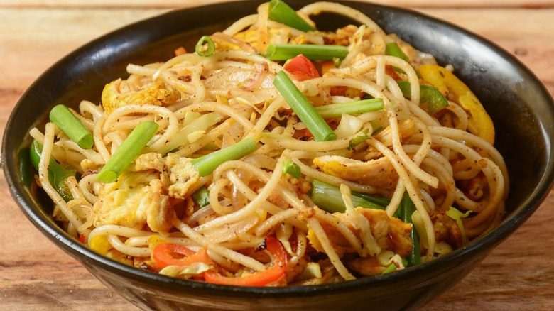 chicken chow mein black bowl wooden table