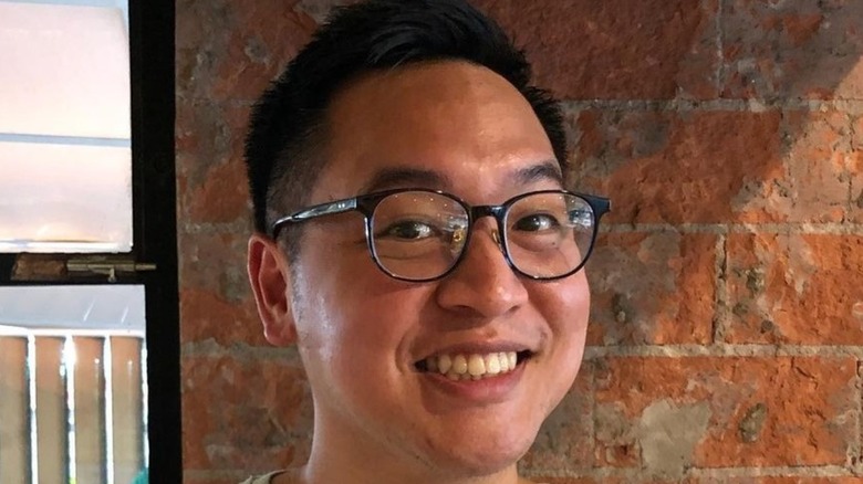 Justin Yu wearing glasses and smiling