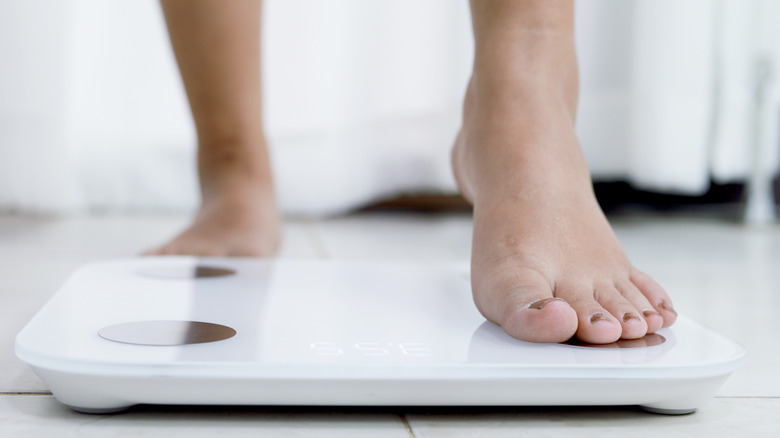 person stepping onto a scale