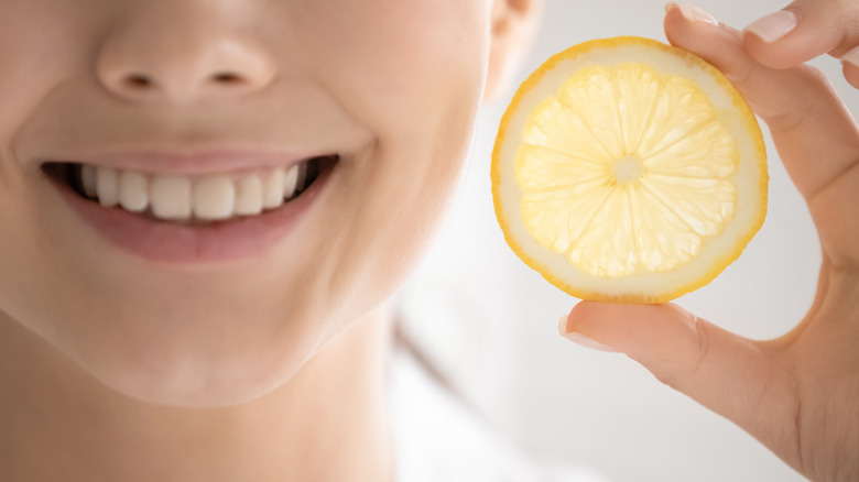 Woman holding lemon slice