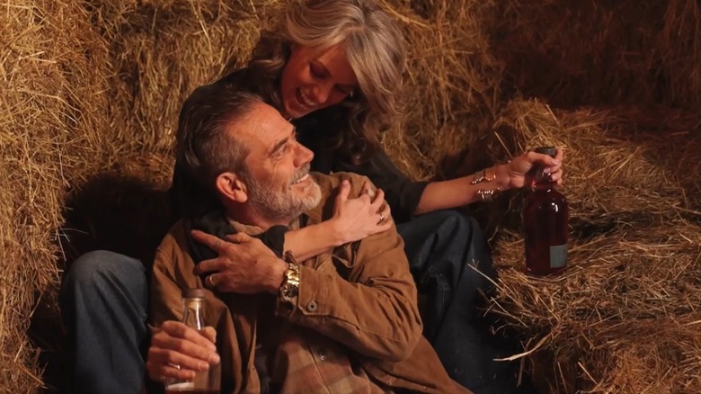 Jeffrey Morgan and Hilarie Burton sitting on hay