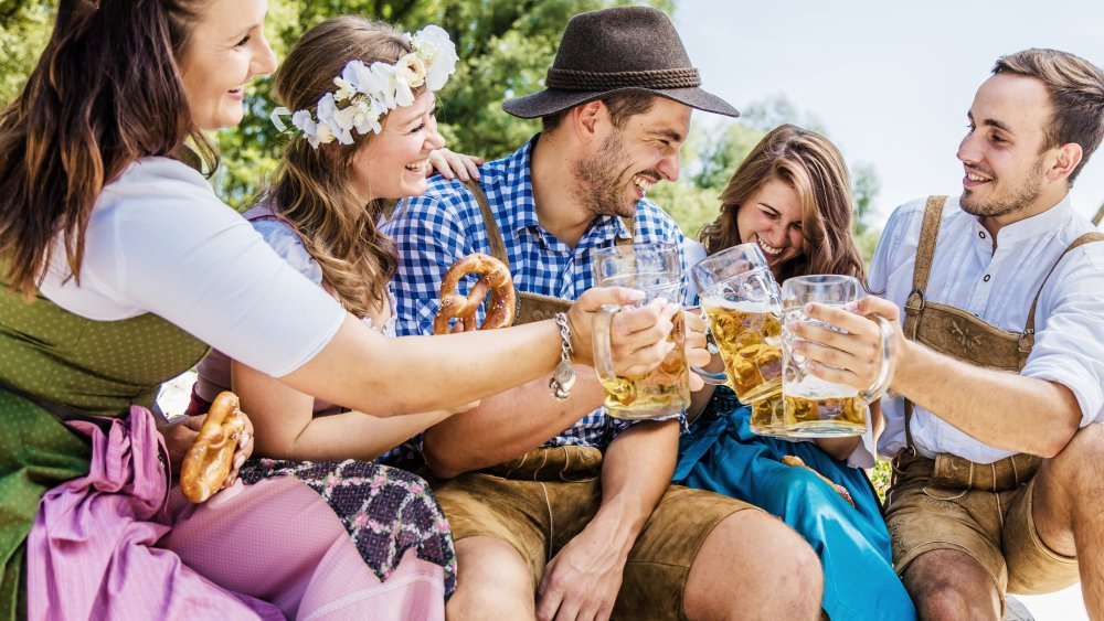 people dressed to celebrate Oktoberfest with pints of beer