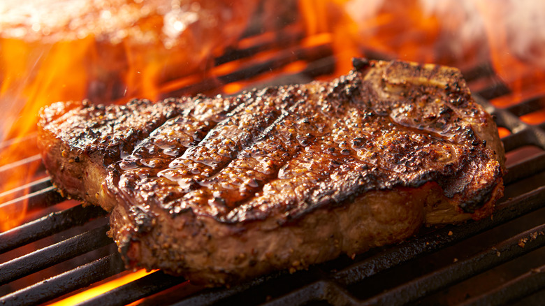 Ribeye steak on flaming grill
