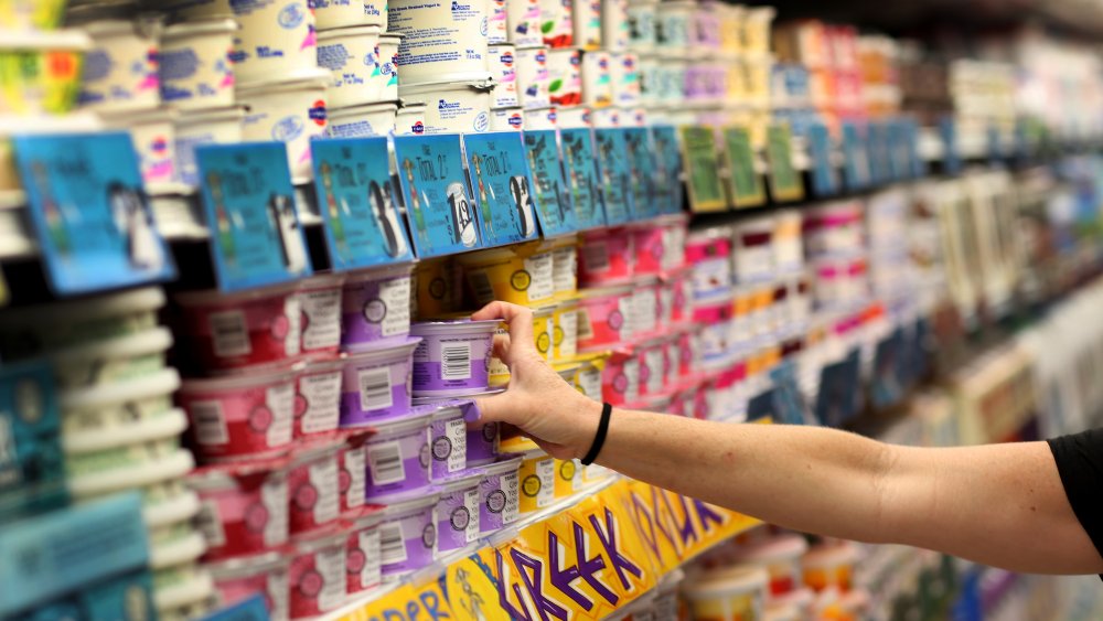 Hand reaching for items on a Trader Joe's shelf