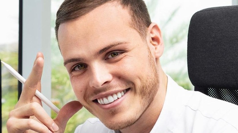 Amaury Guichon smiling and holding pen