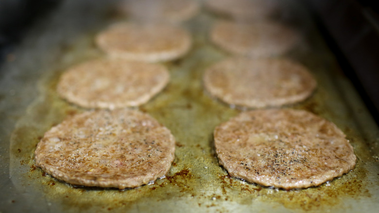 burgers grilling on flat top grill