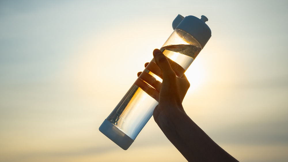 plastic water bottle with setting sun