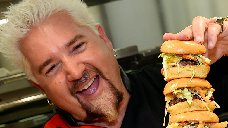 Guy Fieri holding sliders