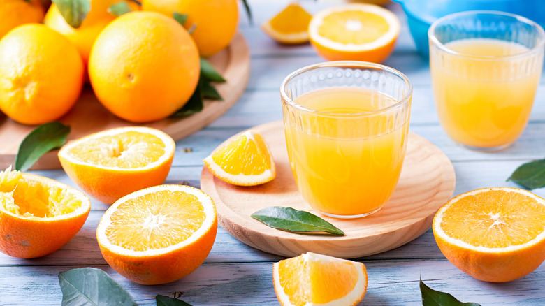 fresh orange juice surrounded by oranges