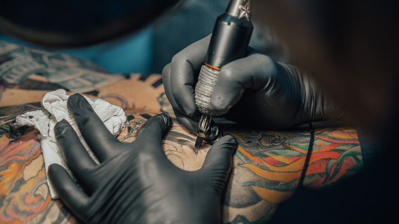 Artist works on a tattoo