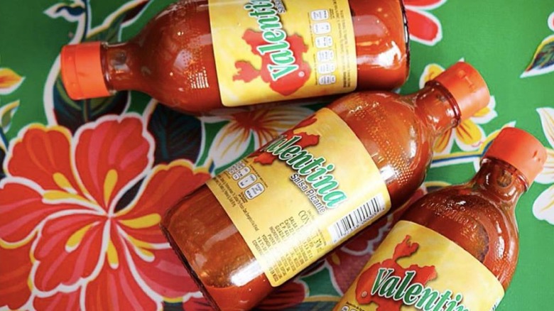 Bottles of Valentina hot sauce on floral background