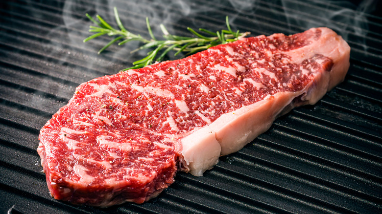 A slab of raw steak on a grill 