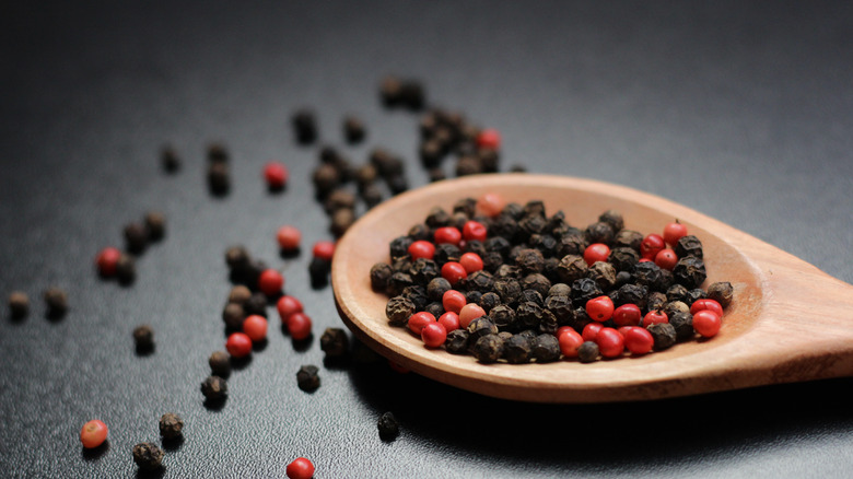 black peppercorns on a wooden spoon